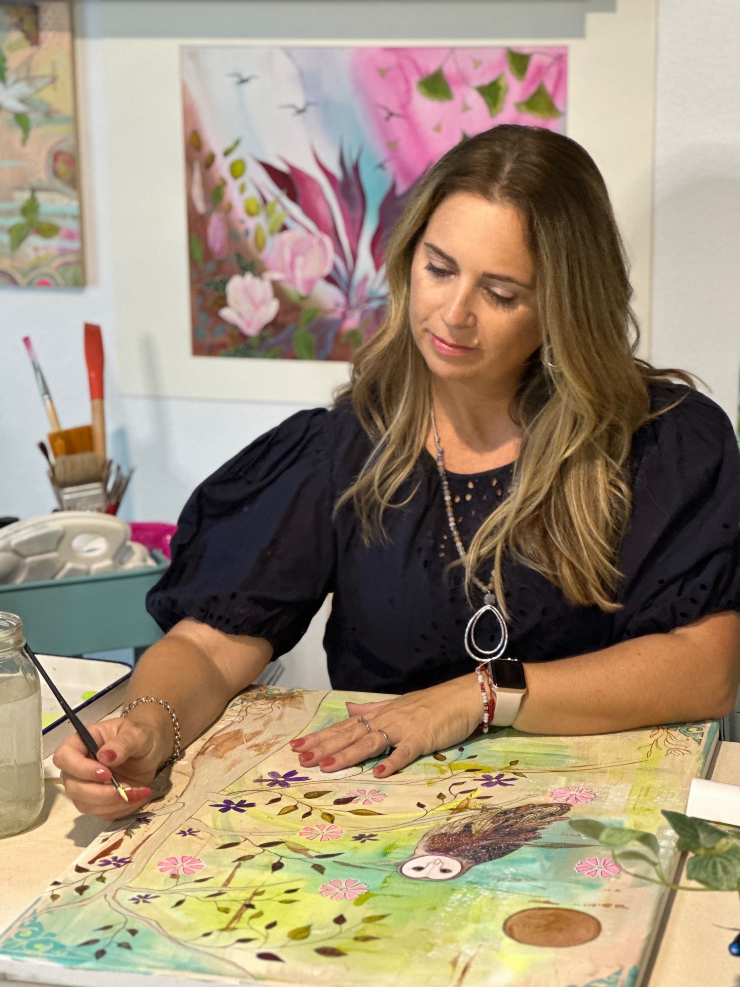 Tania Herrera in her Southern California studio, engaged in her art process, creating a collage that reflects her commitment to nature-inspired artwork and sustainable art practices